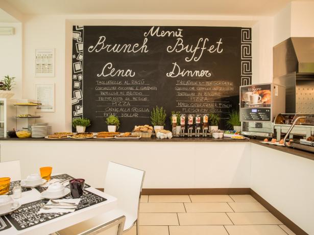 Buffet con menù brunch e cena scritto su lavagna.