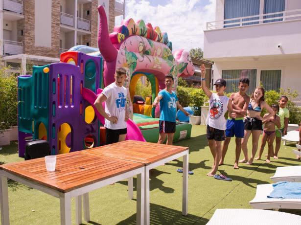 Attività all'aperto con giochi gonfiabili e bambini in piscina.